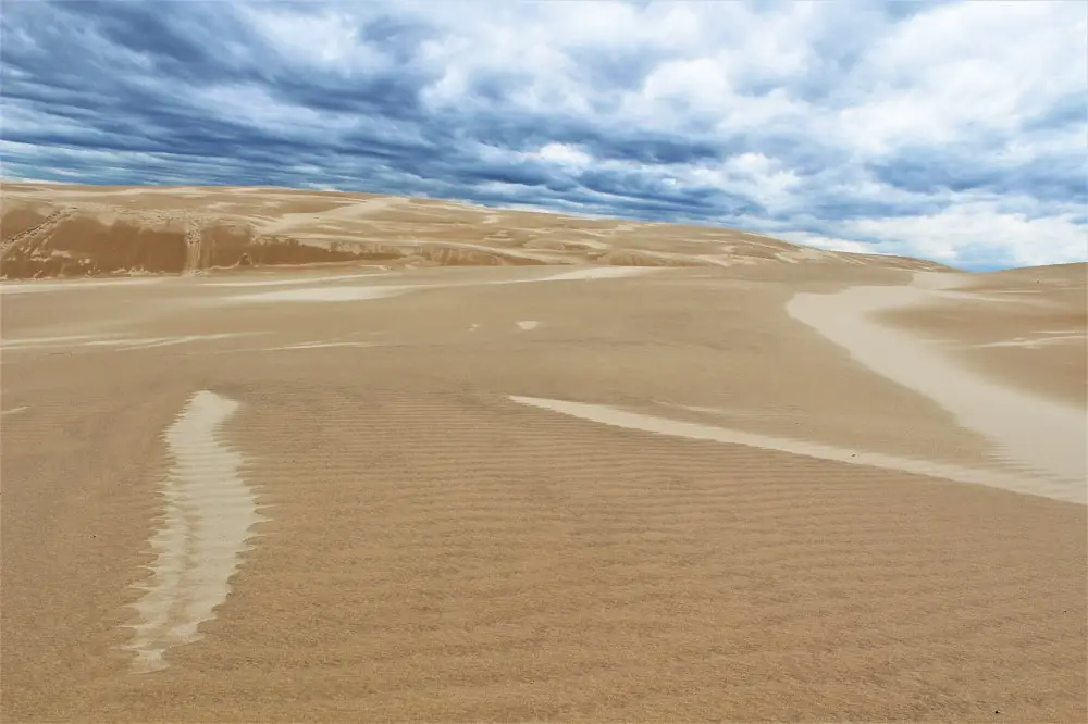 Moody skies over Woromi Sand Dunes, with black clouds and streaky sand.