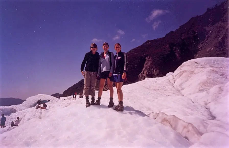 Three female backpackers at Franz Joseph glacier in New Zealand.