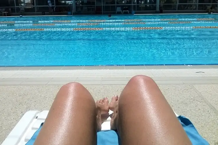 Woman's legs on a sun lounget at Beatty Park swimming pool.