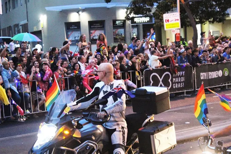 Man on a motorbike with rainbow flags at Mardi Gras Sydney.