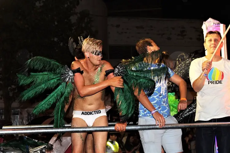 Gay man wearing white underwear and feather wings at Sydney Mardi Gras festival, Australia.