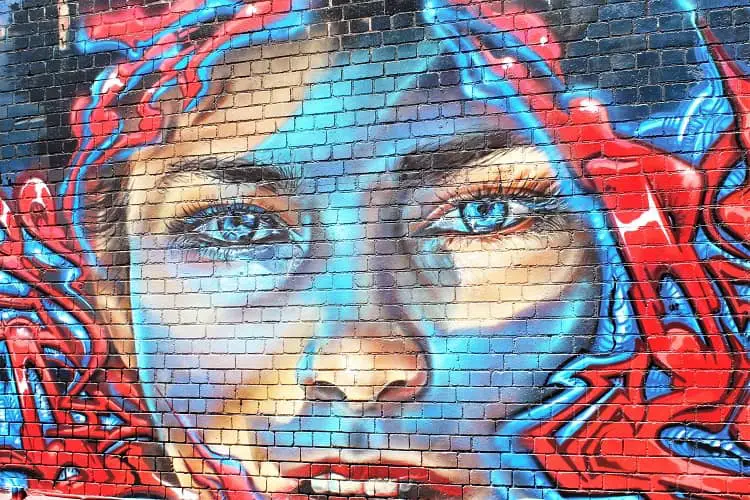 Melbourne street art in Fitzroy: mural of a woman's face with electric blue eyes.