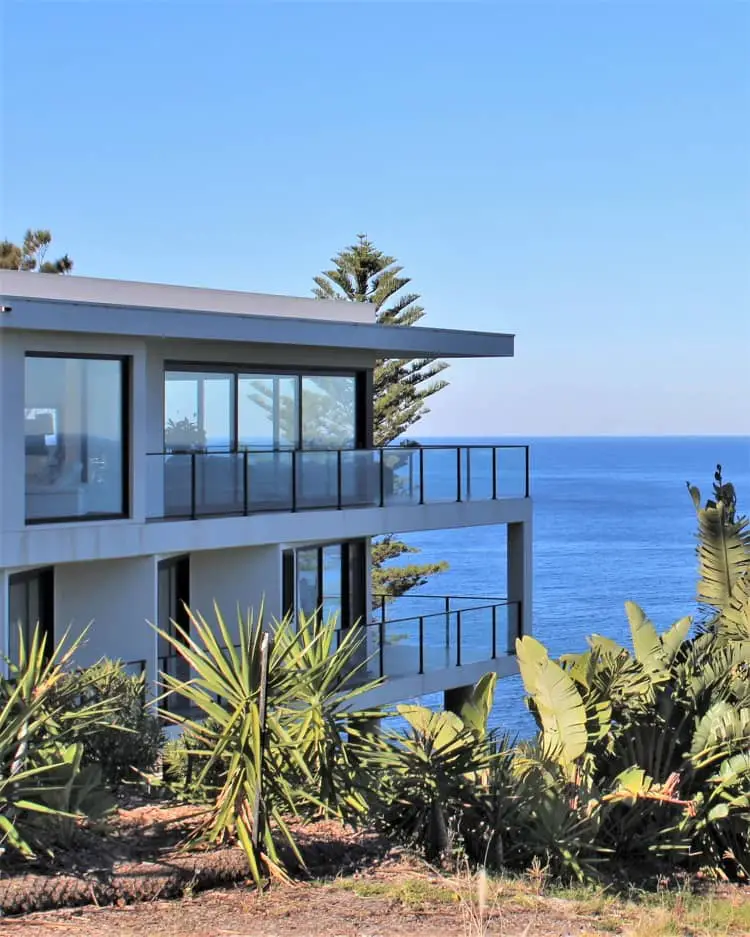 A beautiful modern home with glass balconies overlooking the sea in New South Wales.