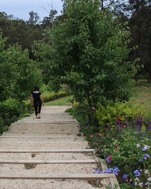 Italian woman walking down the steps through the gardens at Palmyra B&B near Forster NSW.