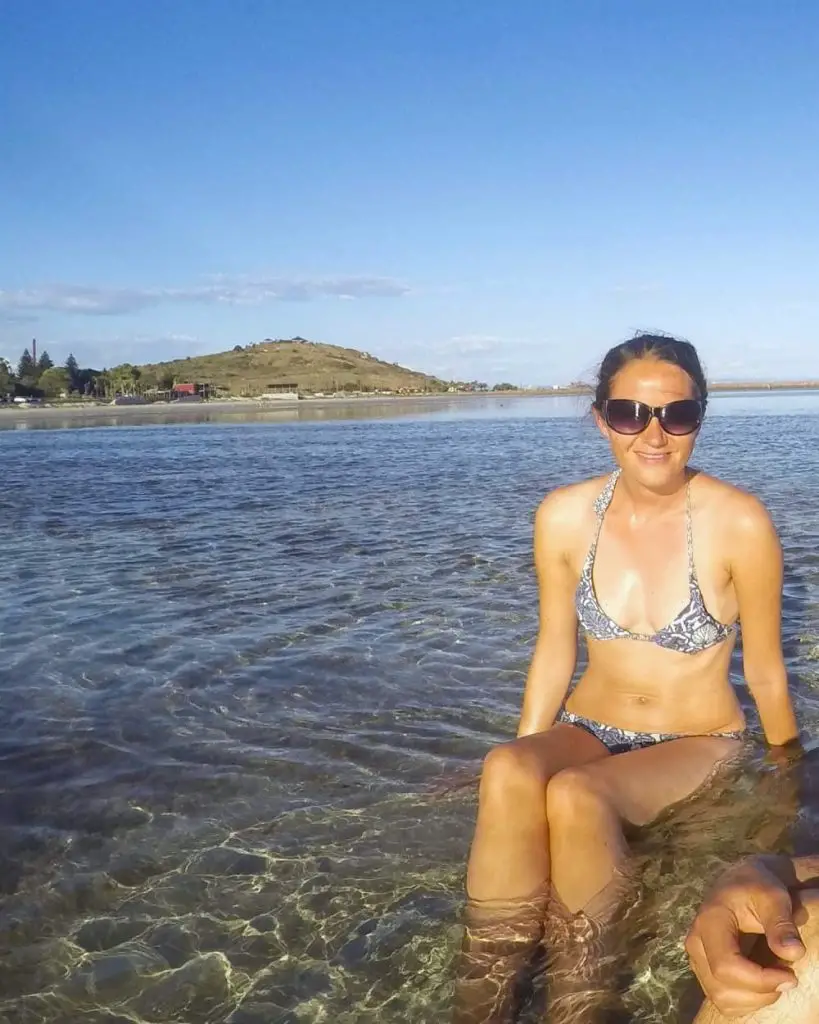 Travel blogger, Lisa Bull, from Dreaming of Down Under, sitting in the shallow sea in Whyalla, South Australia.